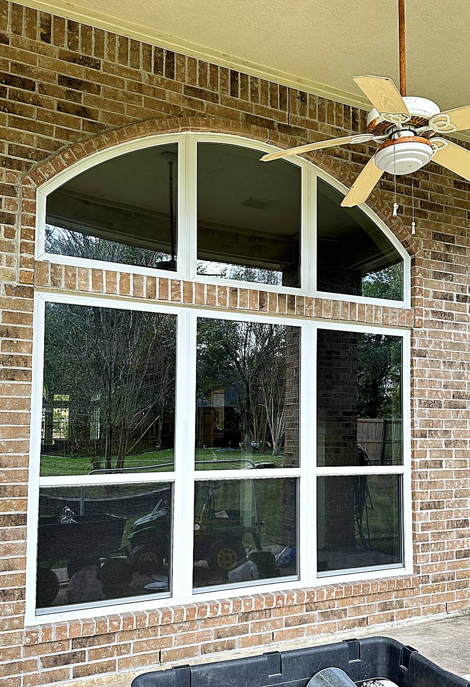 Arched-top window wall on a covered brick patio
